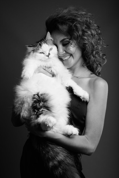 Belle jeune femme aux cheveux bouclés posant en noir et blanc