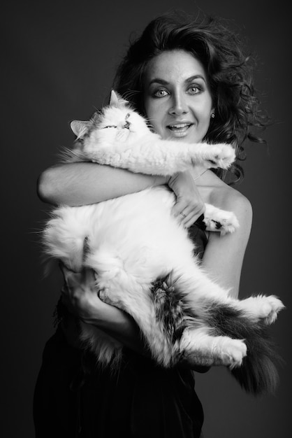 Belle jeune femme aux cheveux bouclés posant en noir et blanc