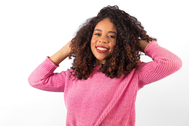 Belle jeune femme aux cheveux bouclés souriant à la caméra