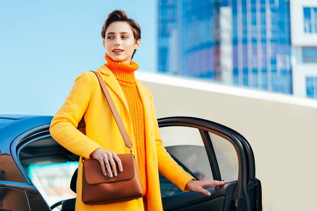 Belle jeune femme aux cheveux courts conduit une voiture dans la ville