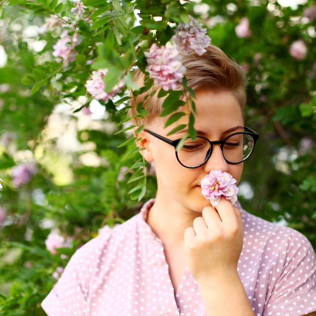 Belle jeune femme aux cheveux courts dans le jardin