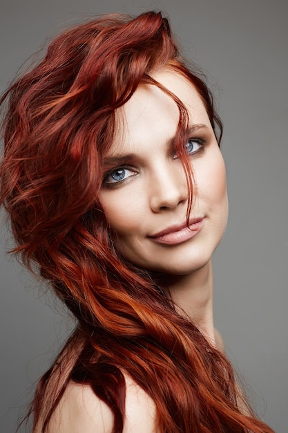 Belle jeune femme aux cheveux rouges bouclés