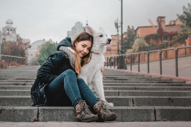 Belle jeune femme aux cheveux roux étreignant et embrassant son chien. L'amour entre le chien et le propriétaire.