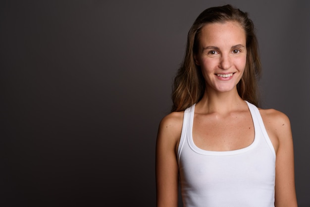 Belle jeune femme aux longs cheveux blonds sur fond gris