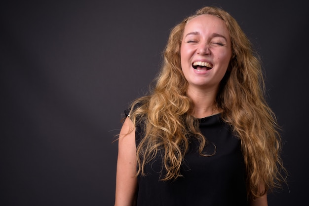 Belle jeune femme aux longs cheveux blonds ondulés