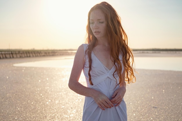 Belle jeune femme aux longs cheveux roux en bonne santé et jolie robe