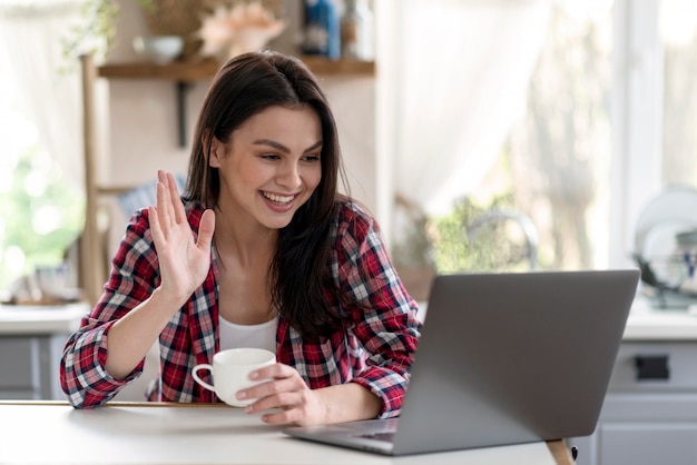 Photo belle jeune femme ayant un appel vidéo