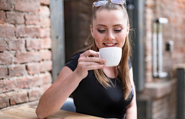 Belle jeune femme ayant un verre à la discothèque