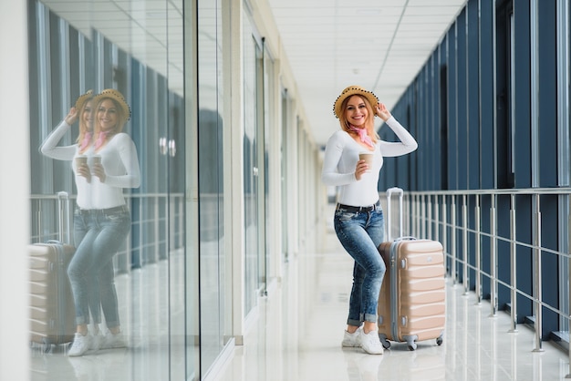 Belle jeune femme avec des bagages à l'aéroport