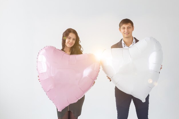 Belle jeune femme avec ballon à air en forme de coeur sur fond blanc avec espace de copie. Femme le jour de la Saint-Valentin. Symbole de l'amour.