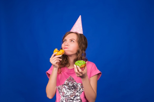 Belle jeune femme avec beignet sur bleu