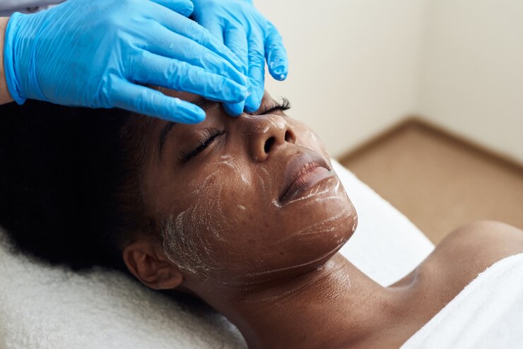 Une belle jeune femme bénéficie d'un massage facial tonifiant. Le concept de soins spa, soins de la peau