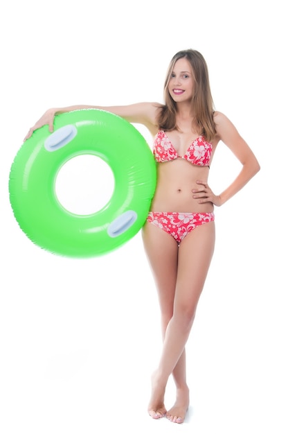 Belle jeune femme en bikini posant avec un gros anneau en caoutchouc vert