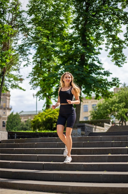 Une belle jeune femme blonde au physique sportif en T-shirt noir