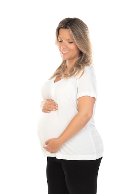 Belle jeune femme blonde enceinte attend bébé sur fond blanc isolé avec un sourire heureux et cool sur le visage