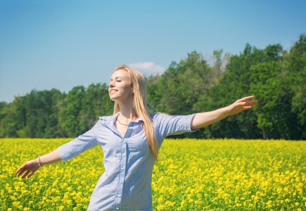 Belle jeune femme blonde se reposant sur une prairie fleurie