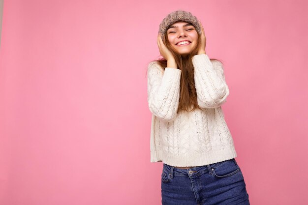 Belle jeune femme brune heureuse et positive isolée sur un mur de fond coloré portant des vêtements décontractés et élégants ressentant des émotions sincères en regardant la caméra