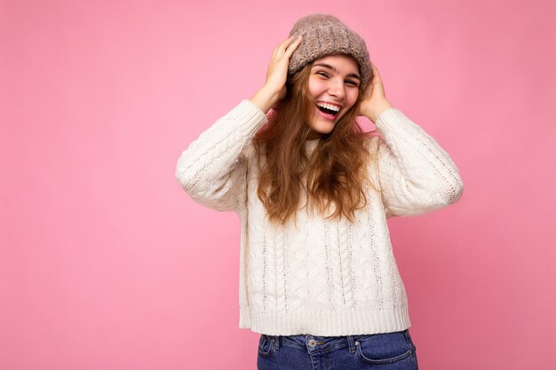 Belle jeune femme brune heureuse et positive isolée sur un mur de fond coloré portant des vêtements décontractés