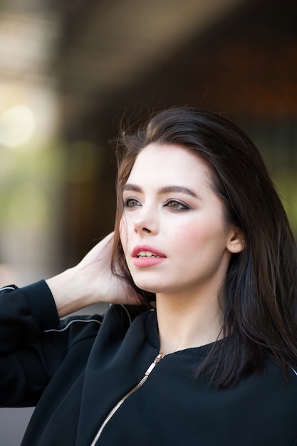 Belle jeune femme brune par temps venteux en plein air