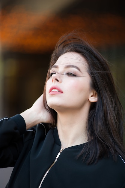 Belle jeune femme brune par temps venteux en plein air