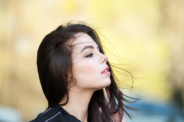 Belle jeune femme brune par temps venteux en plein air