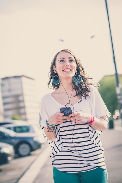 belle jeune femme brune avec un téléphone intelligent