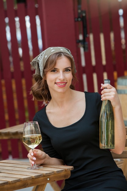 Belle jeune femme buvant du vin blanc sur la terrasse d'un restaurant