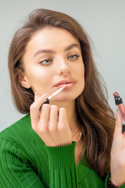 Belle Jeune Femme Caucasienne, Appliquer Le Brillant Sur Les Lèvres En Regardant Dans Le Miroir