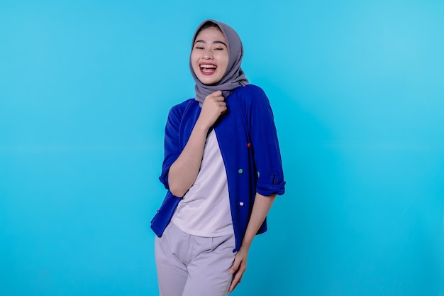 Belle jeune femme charismatique portant le hijab pointant isolé sur fond bleu clair
