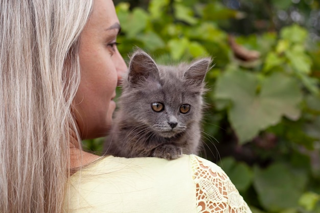 Belle jeune femme avec chat mignon au repos à la maison