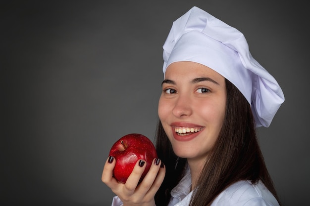 Belle jeune femme chef turque gardant une pomme sur sa main