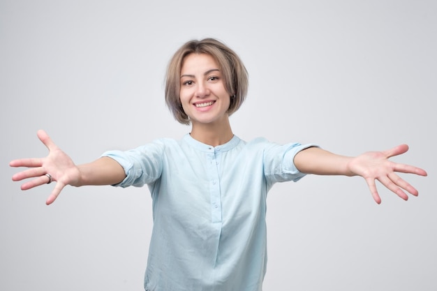 Belle jeune femme en chemise bleue offrant un câlin