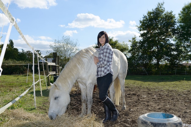 Belle jeune femme et cheval blanc