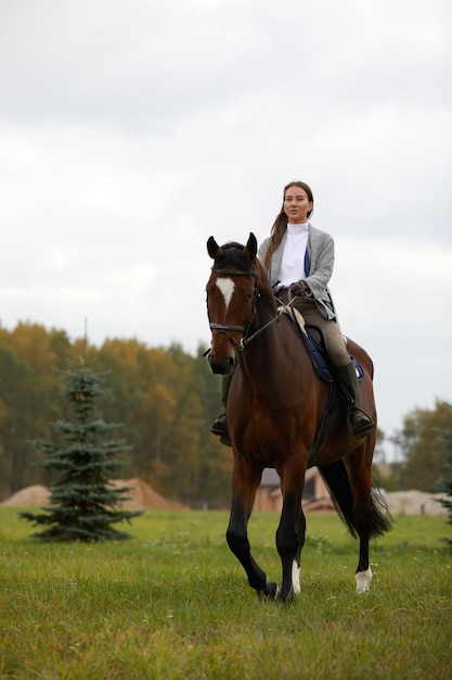 Belle jeune femme à cheval sur le terrain sur le côté de la caméra Mouvement de joie de la liberté