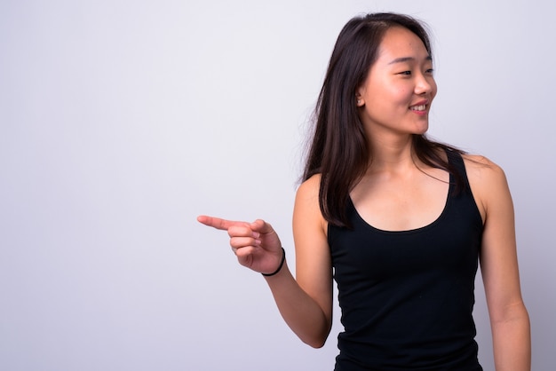 Belle jeune femme chinoise contre le mur blanc