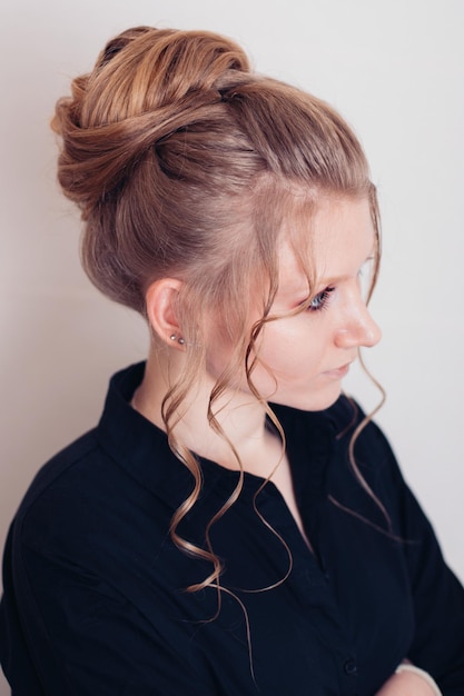 Belle jeune femme avec une coiffure brune sur fond blanc