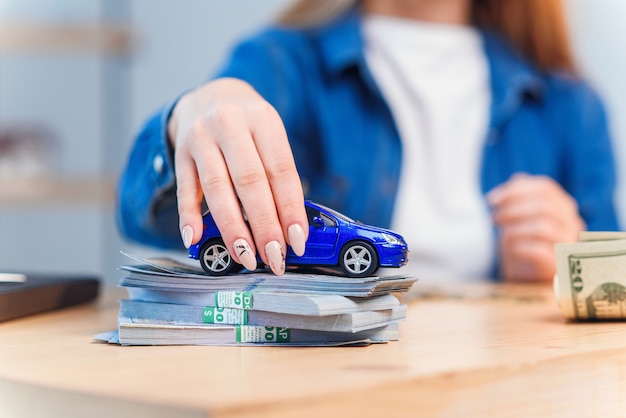 Belle jeune femme compte des économies pour acheter son propre véhicule.