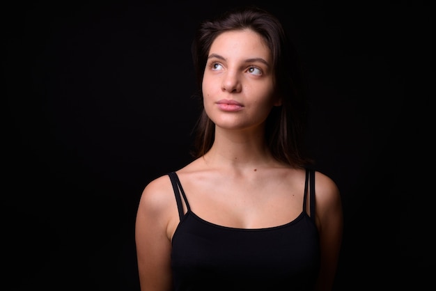 belle jeune femme contre le mur noir