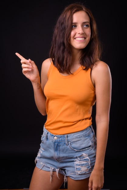 belle jeune femme contre le mur noir