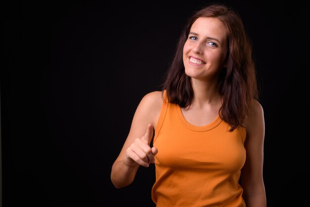 belle jeune femme contre le mur noir