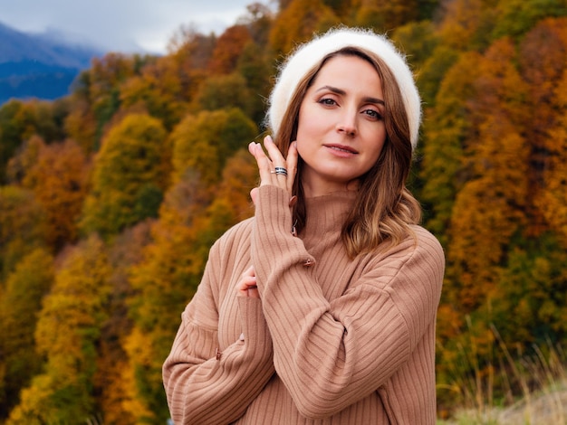 Belle jeune femme en costume beige et un béret angora en automne dans les montagnes