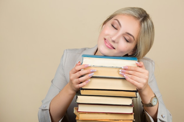 belle jeune femme en costume dort à une table avec des livres