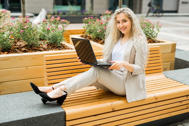 belle jeune femme en costume avec ordinateur portable