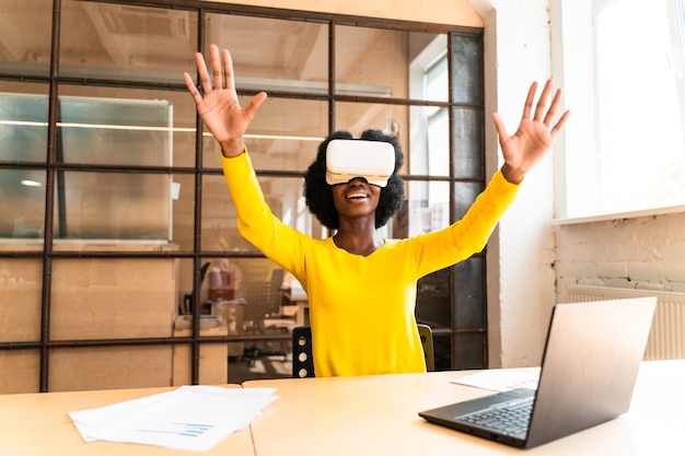 Belle jeune femme avec la coupe de cheveux afro travaillant au bureau