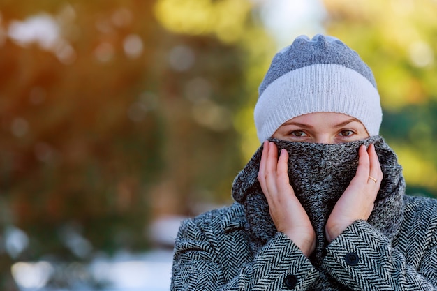 Photo belle jeune femme dans un bonnet de fourrure shaggy gris et des vêtements d'hiver chauds pendant la neige