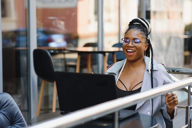 Belle jeune femme dans un café à l'aide d'un ordinateur portable