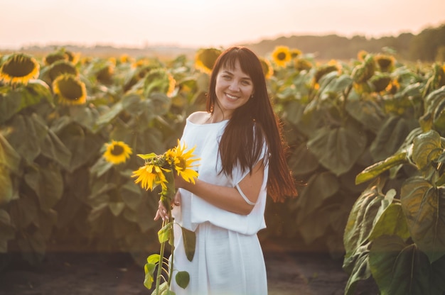 Belle jeune femme dans un champ de tournesol. Portrait d'une jeune femme au soleil. Concept d'allergies au pollen. Bonheur en plein air