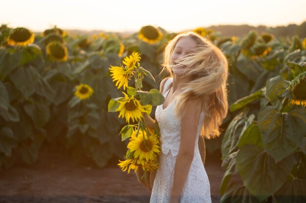 Belle jeune femme dans un champ de tournesol. Portrait d'une jeune femme au soleil. Concept d'allergies au pollen. Bonheur en plein air