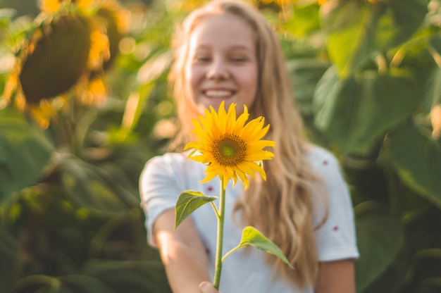 Belle jeune femme dans un champ de tournesol. Portrait d'une jeune femme au soleil. Concept d'allergies au pollen