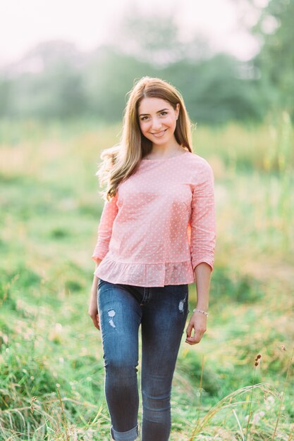 Belle jeune femme dans une chemise rose dans la nature